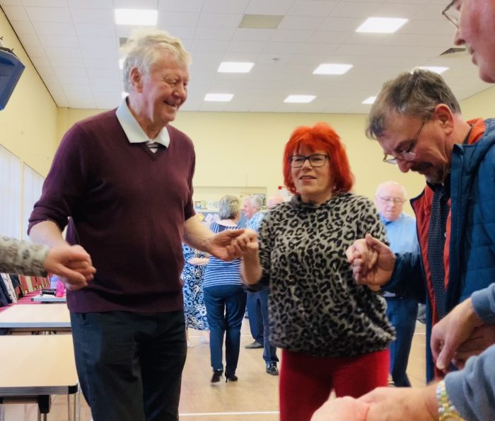 St Pauls Centre volunteer helping at a tea dance for a dementia group